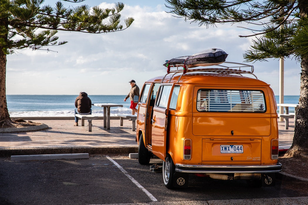 orange Volkswagen Kombi parked at the beach