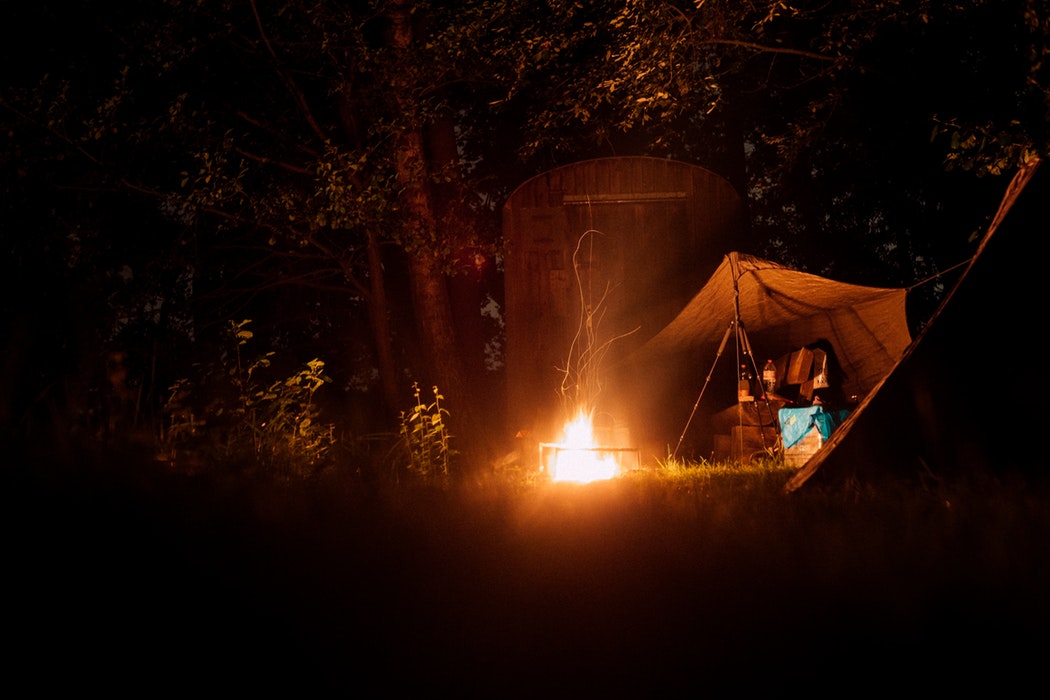 amping at night with a campfire and tent